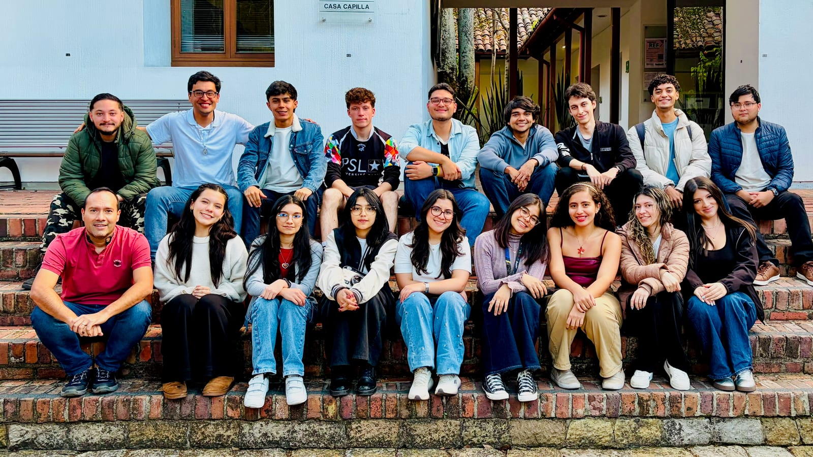The Nanomagnetism Laboratory group, nineteen people seated on the steps outside Casa Capilla